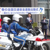 パトロールに出動する白バイを見送る青山千葉県警本部長（右）と熊谷知事（左隣）＝６日午前９時半、千葉市中央区